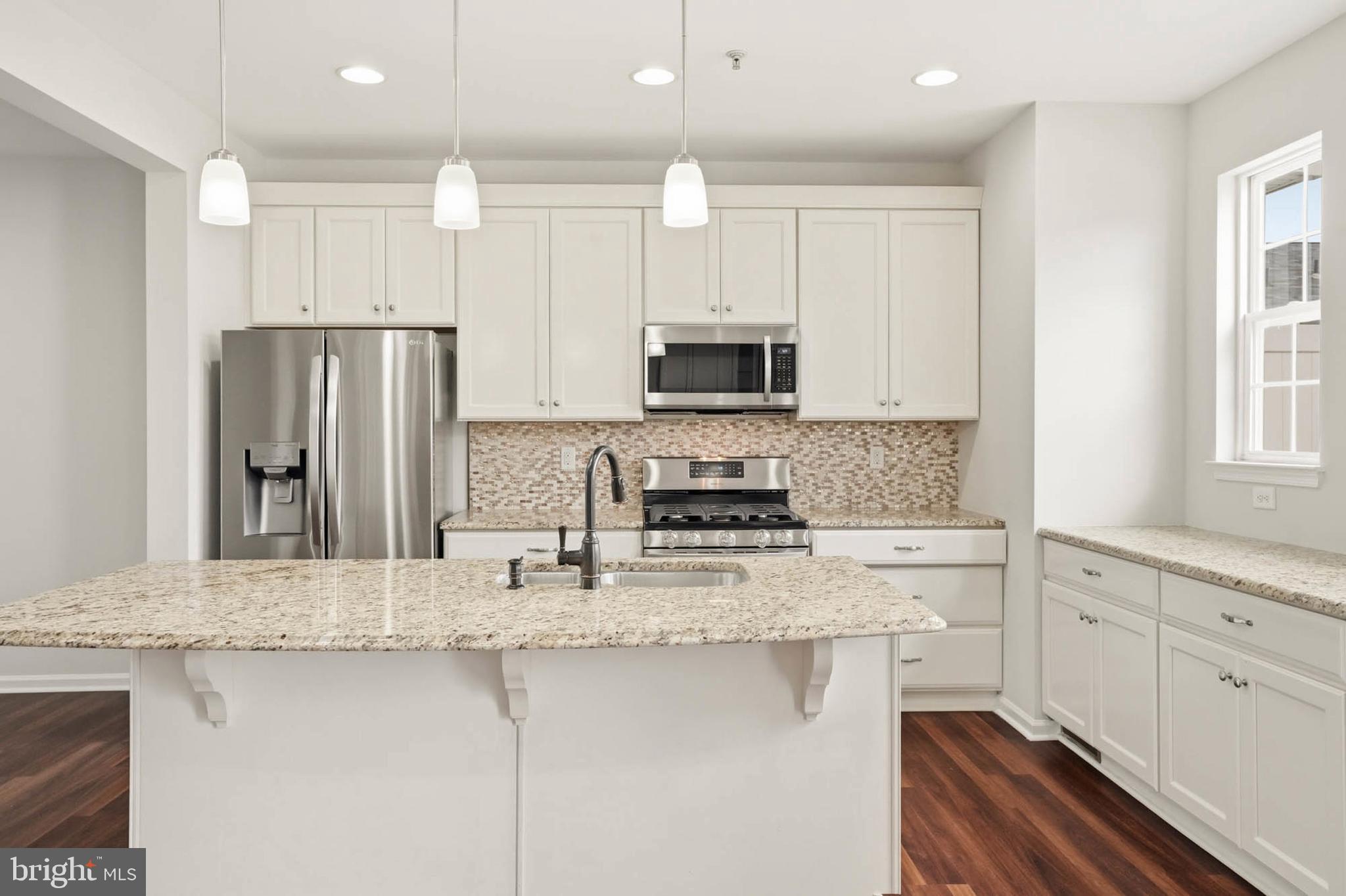 9817 Solar Course Laurel, MD 20723 - Photo 7 of 59 a kitchen with stainless steel appliances granite countertop a stove a sink a refrigerator and white cabinets with wooden floor
