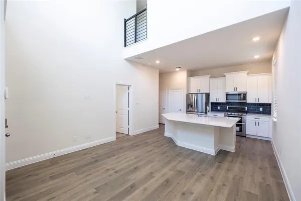 a view of kitchen with wooden floor and electronic appliances