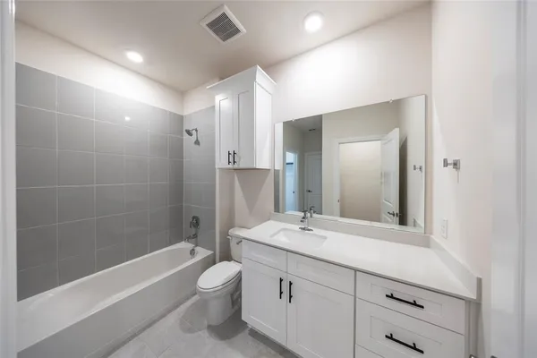 a bathroom with a double vanity sink toilet mirror and bathtub