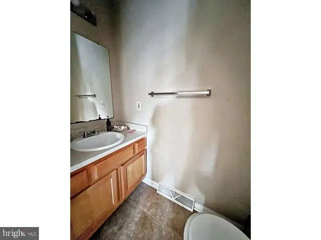 a bathroom with a granite countertop sink mirror vanity and toilet