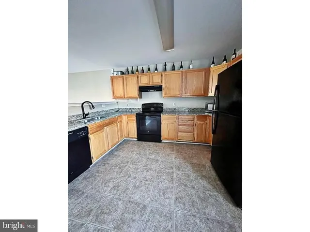 a kitchen with stainless steel appliances granite countertop a sink and a stove