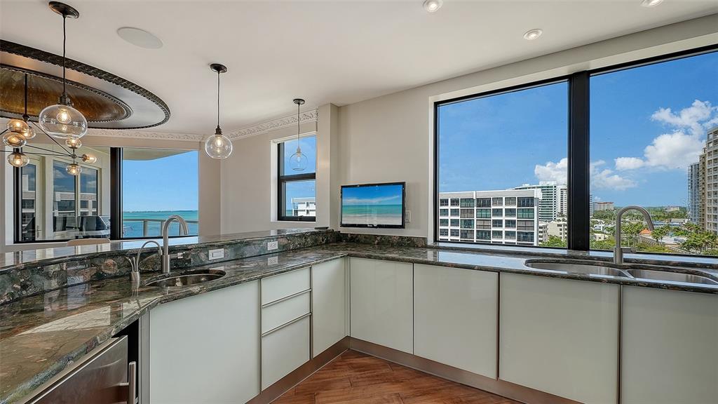 128 Golden Gate Point, Unit 901/1001 Sarasota, FL 34236 - Photo 15 of 55 a kitchen with a sink and a large window