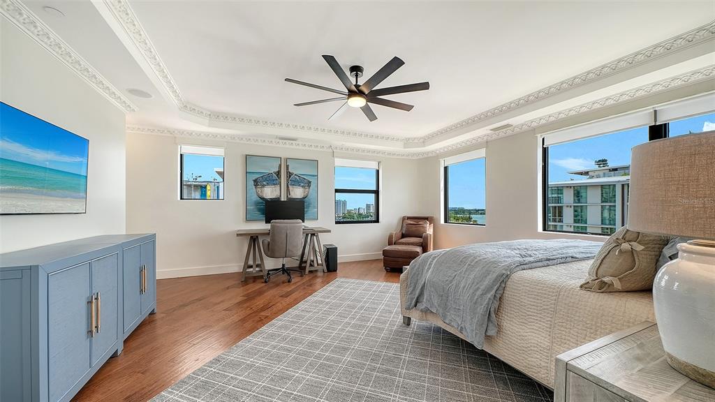 128 Golden Gate Point, Unit 901/1001 Sarasota, FL 34236 - Photo 19 of 55 a bedroom with a bed and wooden floor