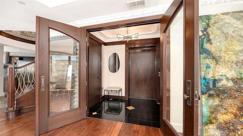 128 Golden Gate Point, Unit 901/1001 Sarasota, FL 34236 - Photo 2 of 55 a view of a hallway with wooden floor and door