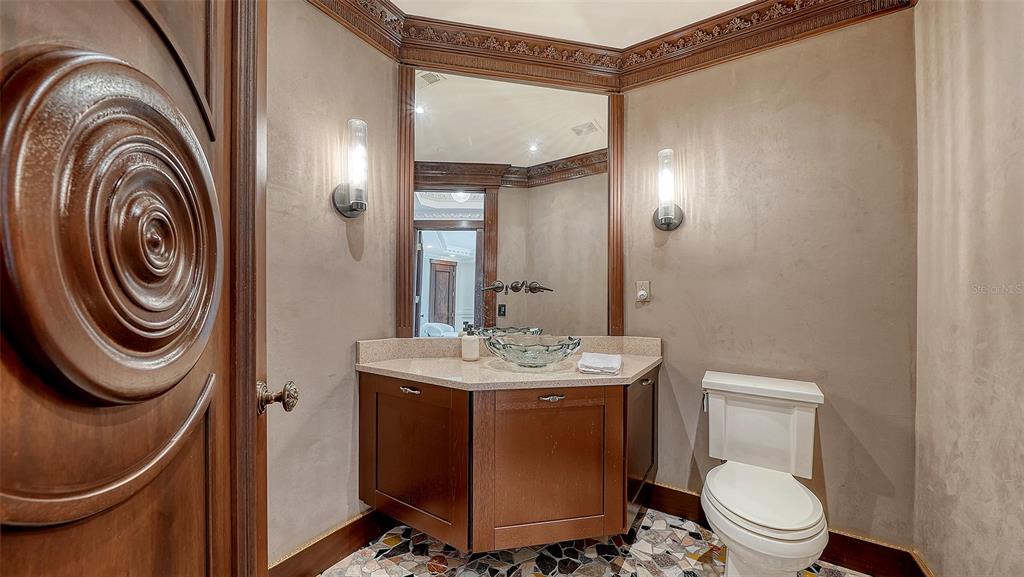 128 Golden Gate Point, Unit 901/1001 Sarasota, FL 34236 - Photo 26 of 55 a bathroom with a sink a toilet and a mirror