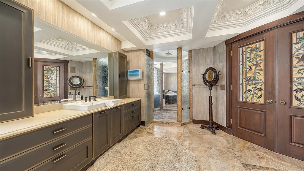 128 Golden Gate Point, Unit 901/1001 Sarasota, FL 34236 - Photo 34 of 55 a spacious bathroom with a sink a mirror and shower
