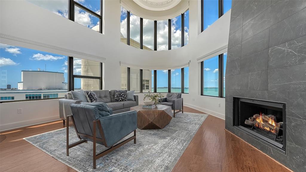 128 Golden Gate Point, Unit 901/1001 Sarasota, FL 34236 - Photo 6 of 55 a living room with furniture a flat screen tv and a fireplace