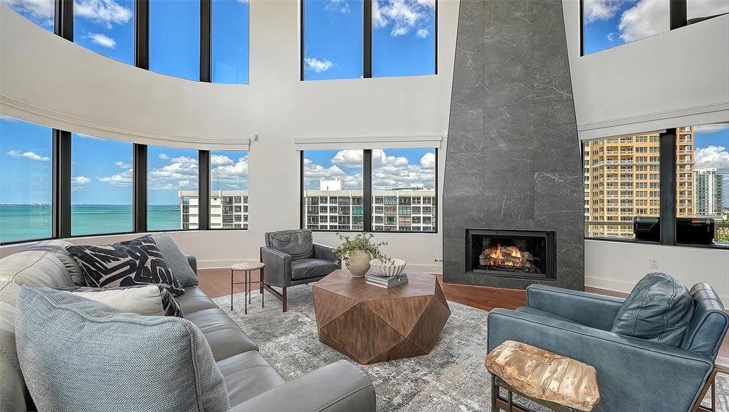 128 Golden Gate Point, Unit 901/1001 Sarasota, FL 34236 - Photo 8 of 55 a living room with furniture and a fireplace