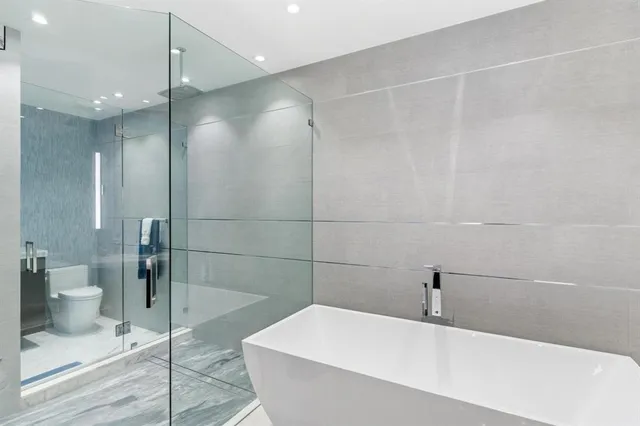 a bathroom with a granite countertop sink a toilet and a mirror