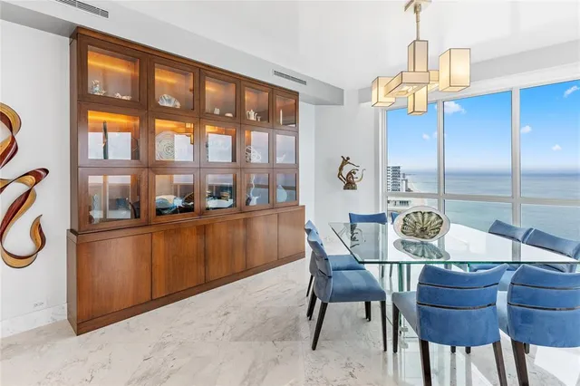 a dining room with furniture a chandelier and wooden floor