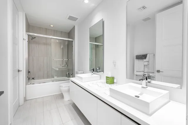 a bathroom with a bathtub double vanity sink and mirror