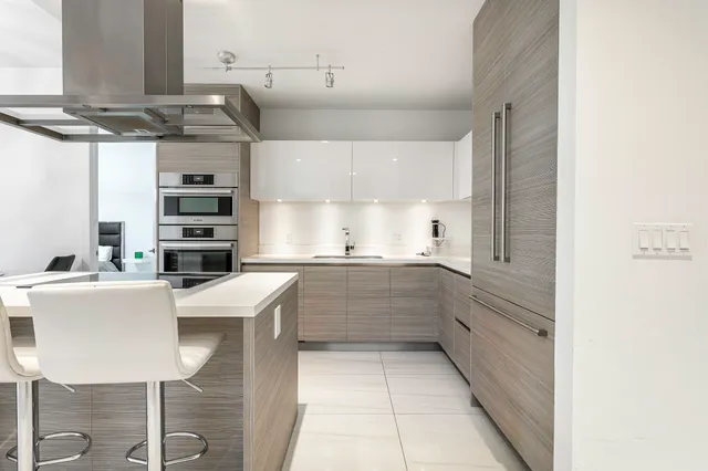 a kitchen with stainless steel appliances a refrigerator and a stove top oven