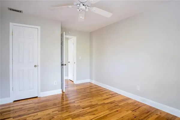 a view of an empty room with wooden floor