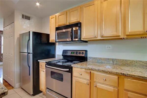 a kitchen with granite countertop white cabinets and stainless steel appliances
