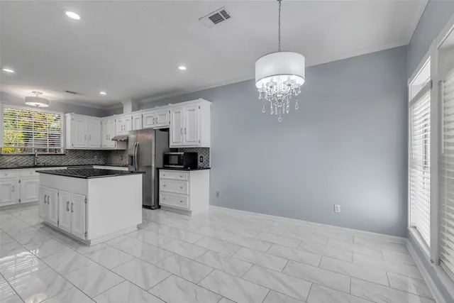 a kitchen with granite countertop a refrigerator stove and sink