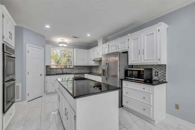 a kitchen with stainless steel appliances granite countertop a stove and a refrigerator