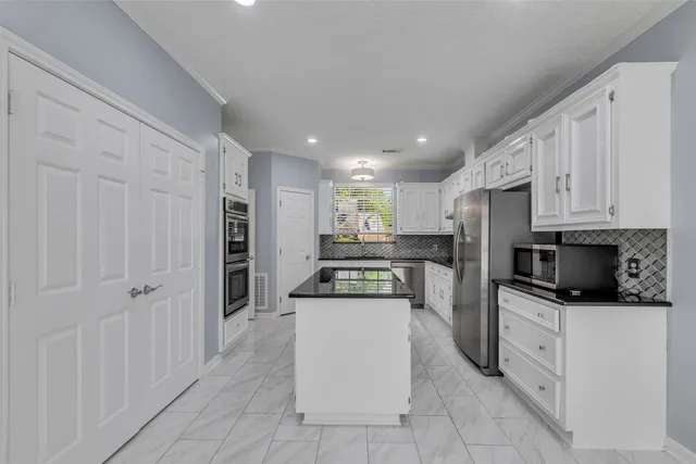 a kitchen with stainless steel appliances granite countertop a stove and a refrigerator