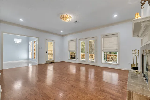 a view of an empty room with a window and wooden floor