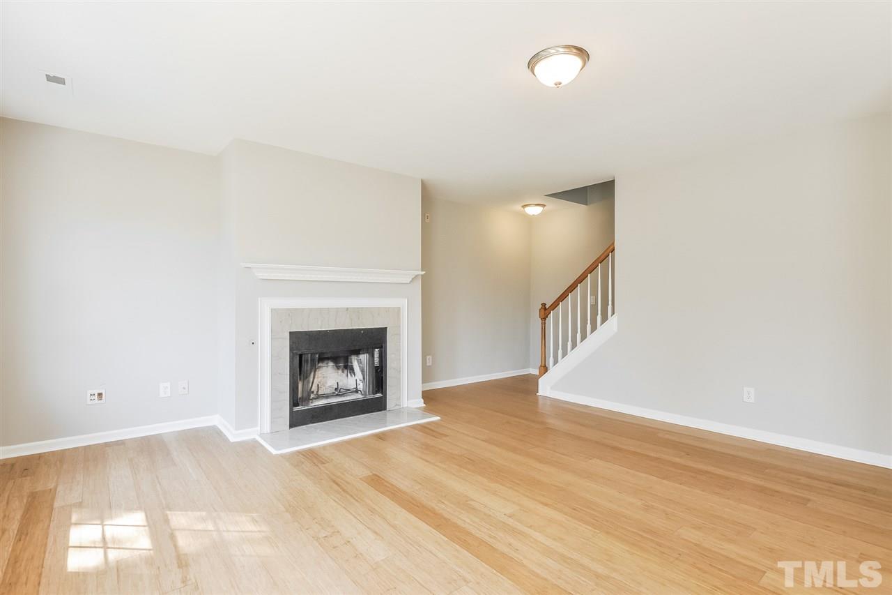 5100 Marathon Lane Raleigh, NC 27616 - Photo 3 of 24 a view of an empty room with wooden floor and a fireplace