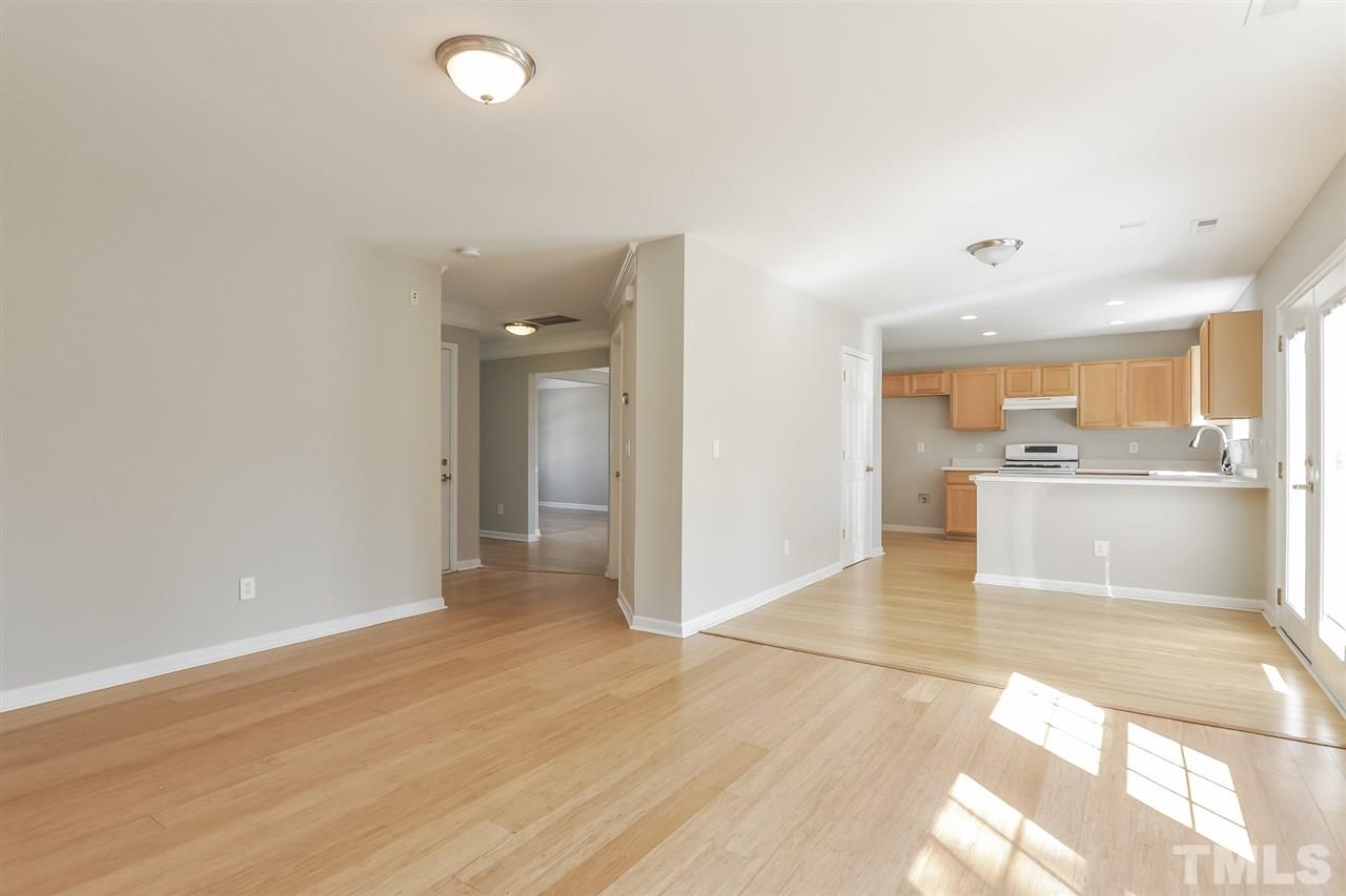 5100 Marathon Lane Raleigh, NC 27616 - Photo 8 of 24 a view of a kitchen with kitchen island a sink wooden floor and a refrigerator
