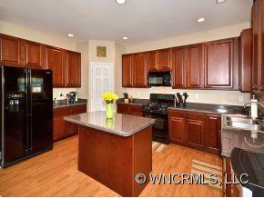 30 Woodfern Road Fletcher, NC 28732 - Photo 5 of 19 a kitchen with stainless steel appliances granite countertop a stove top oven a refrigerator a sink and dishwasher with wooden floor