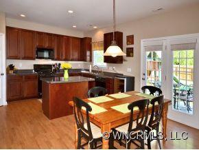 30 Woodfern Road Fletcher, NC 28732 - Photo 6 of 19 a kitchen with a dining table chairs stainless steel appliances and cabinets