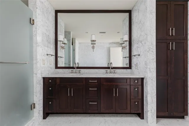 a modern kitchen with stainless steel appliances granite countertop a refrigerator a sink and wooden cabinets