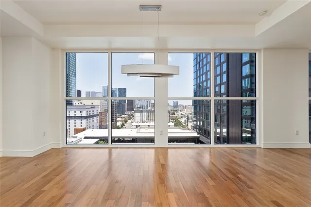 a view of empty room with wooden floor and fireplace