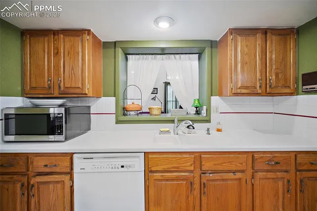 a kitchen with stainless steel appliances wooden cabinets and a window