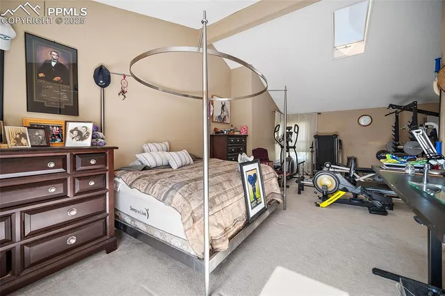 a bedroom with a bed a lamp and a mirror on the dresser