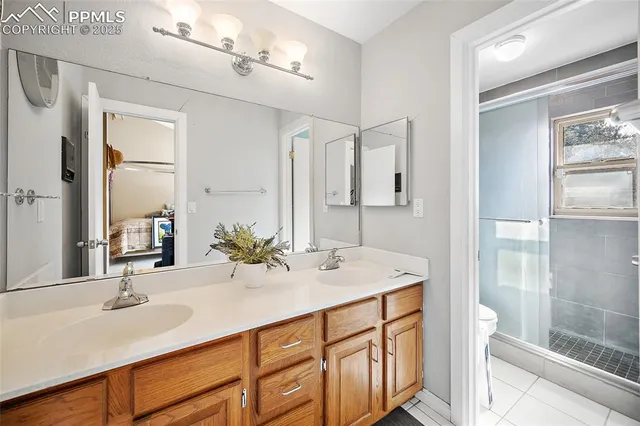 a bathroom with double vanity sink a toilet and a mirror