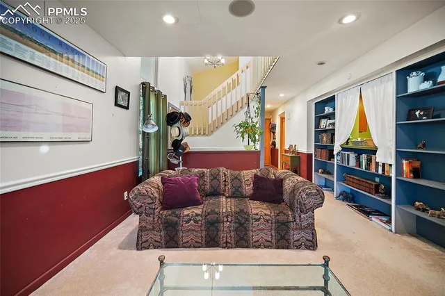 a living room with furniture and a book shelf