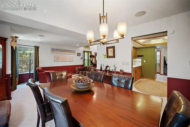 a view of a dining room with furniture a chandelier and wooden floor