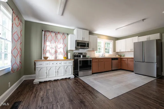 a kitchen with granite countertop a refrigerator and a stove top oven