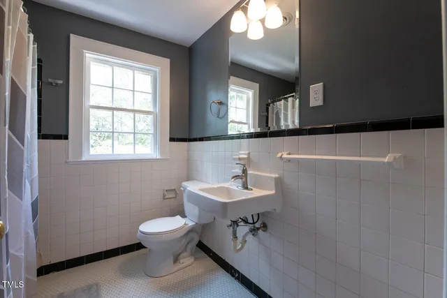 a bathroom with a toilet a sink and mirror