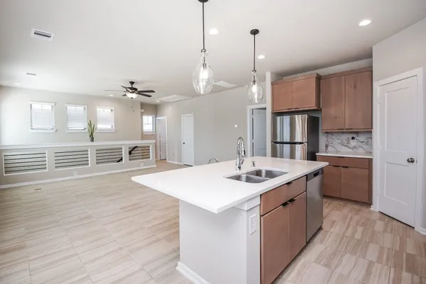 a kitchen with stainless steel appliances granite countertop a sink a stove and a wooden floors