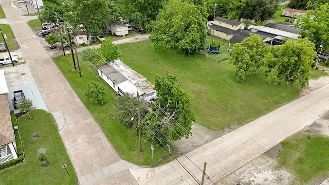 a view of a big house with a big yard and large trees