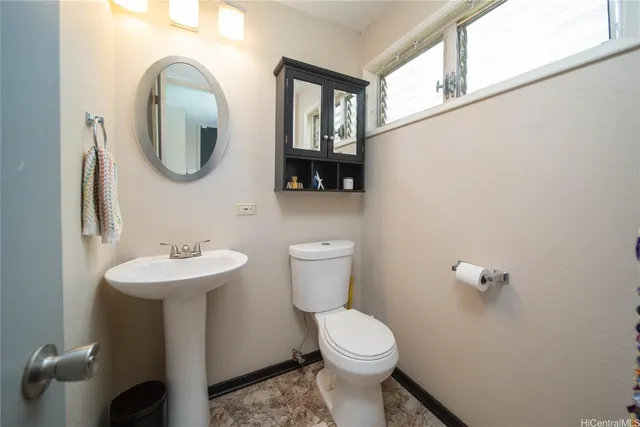 a bathroom with a toilet sink and mirror
