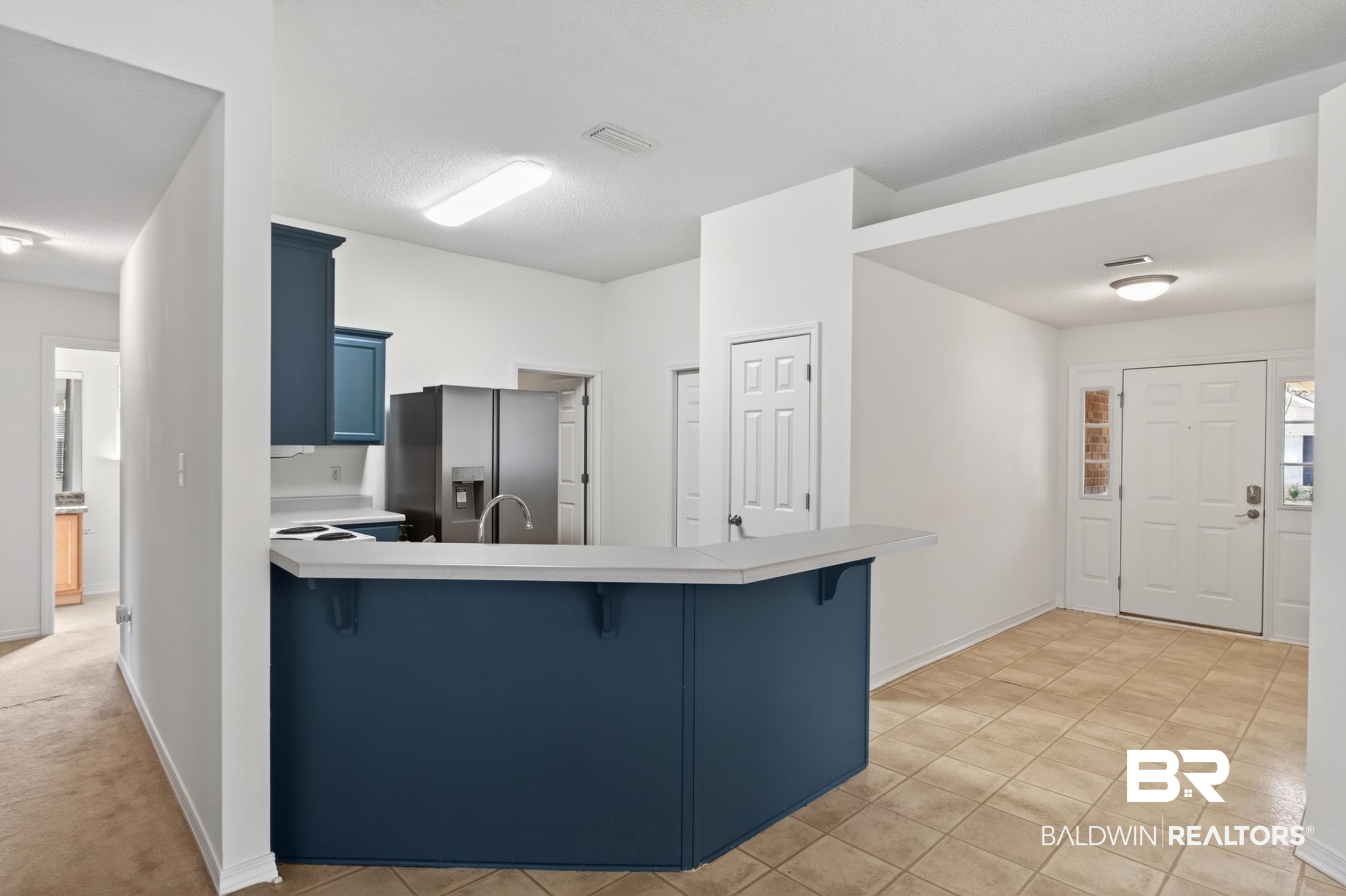 108 Davison Loop Fairhope, AL 36532 - Photo 5 of 17 Kitchen featuring a kitchen breakfast bar, blue cabinetry, light countertops, stainless steel refrigerator with ice dispenser, and a peninsula