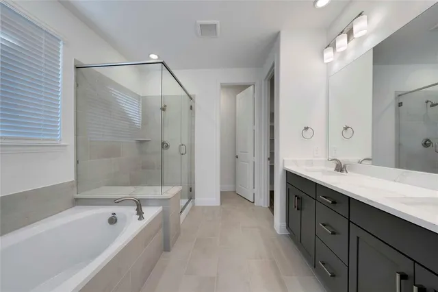 a spacious bathroom with a tub sink shower and mirror