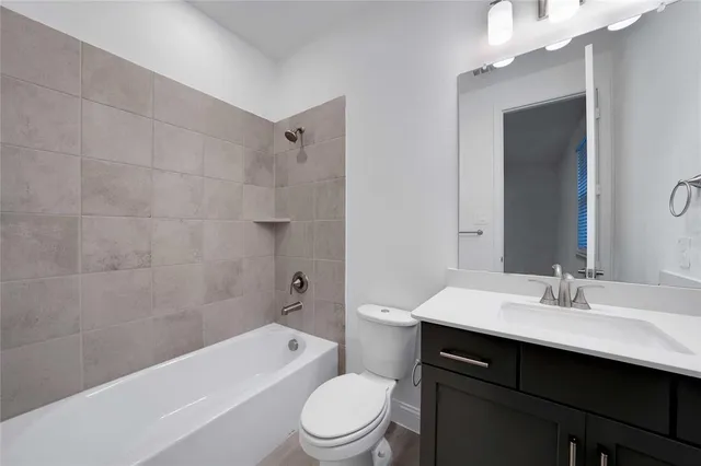 a bathroom with a sink a toilet a mirror a bathtub and shower