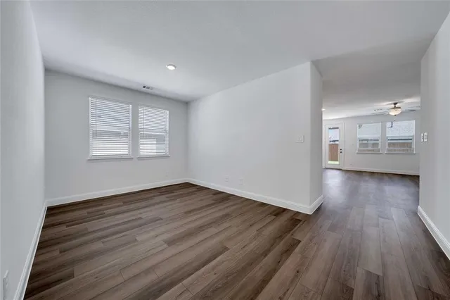 an empty room with wooden floor and a window