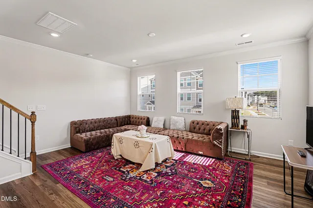a large white kitchen with wooden floor and stainless steel appliances