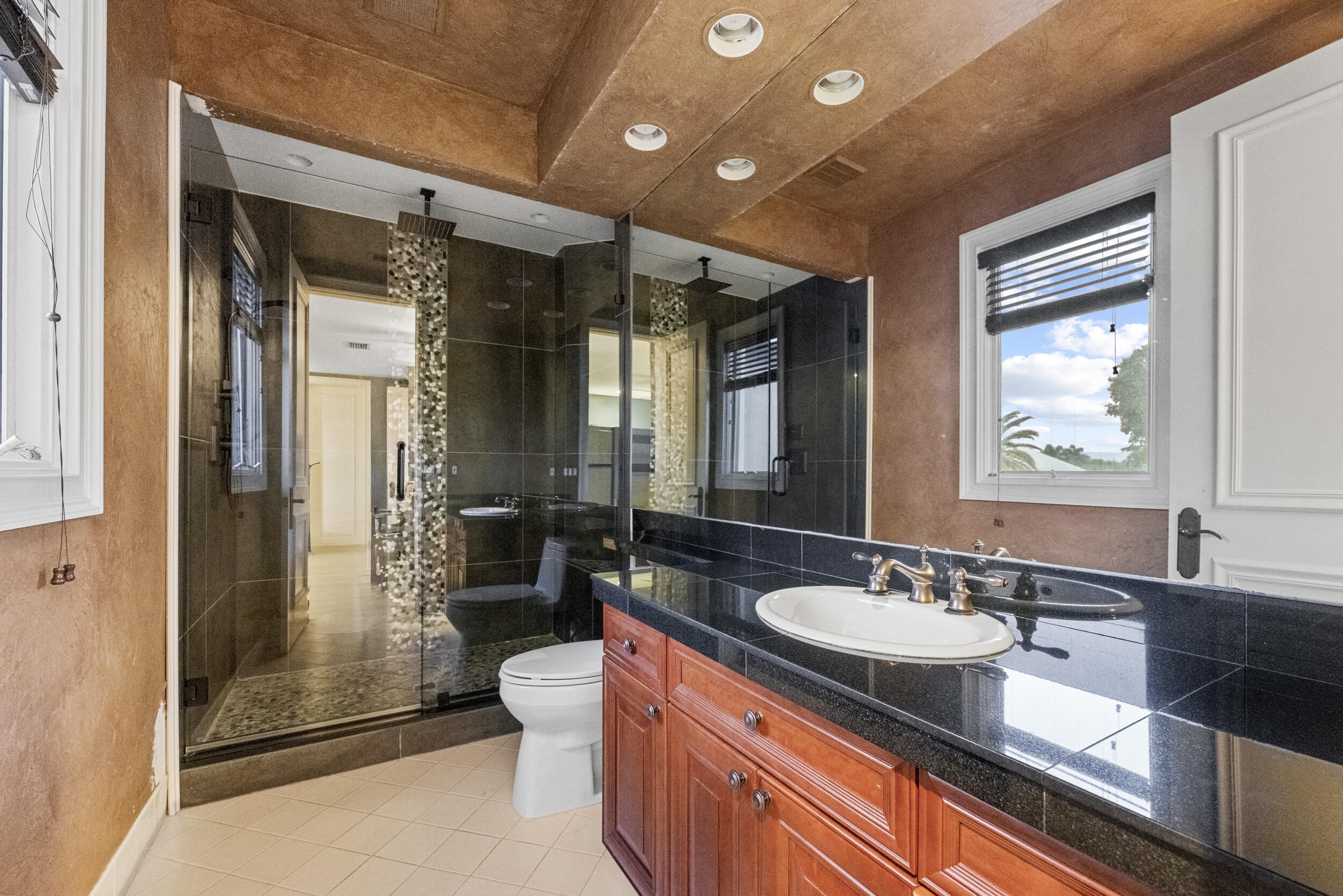 21169 Oakley Court Boca Raton, FL 33433 - Photo 30 of 60 a bathroom with a granite countertop sink a toilet a mirror and shower