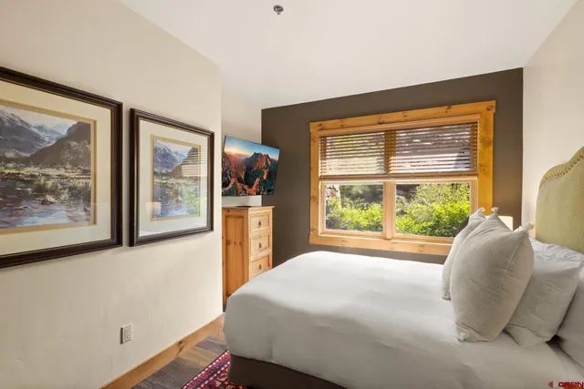 a bed sitting in a bedroom next to a window