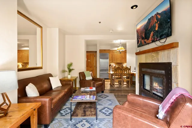 a living room with furniture a flat screen tv and a fireplace
