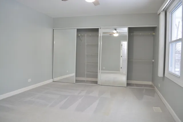 an empty room with windows and closet