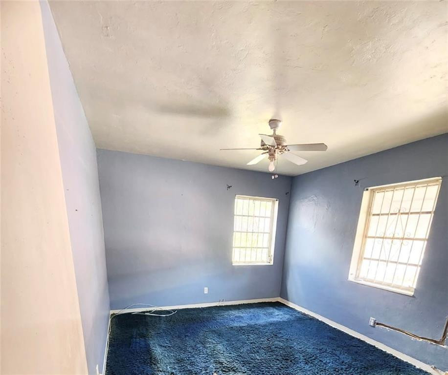 75 Northwest 52nd Street Miami, FL 33127 - Photo 10 of 12 an empty room with windows and chandelier fan