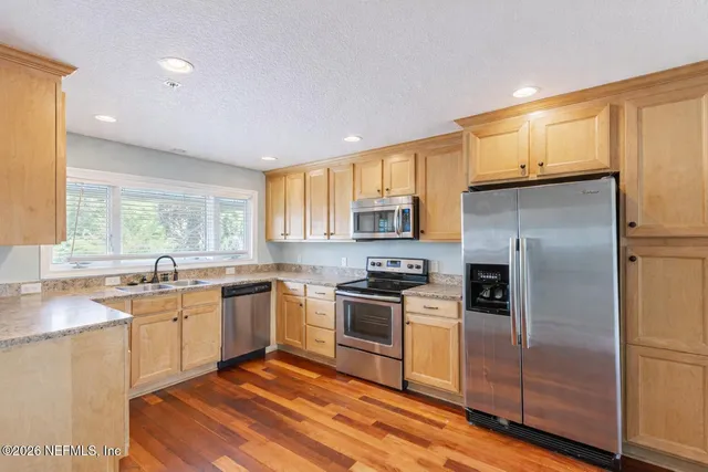 a kitchen with a sink a refrigerator and window