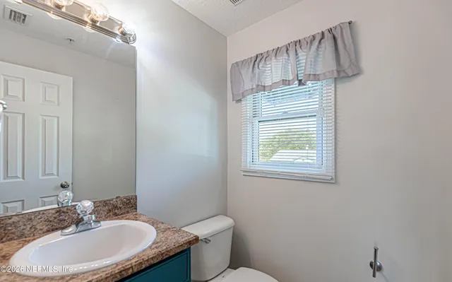 a bathroom with a sink a toilet and mirror